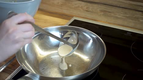 woman making american pancakes with a frying pan