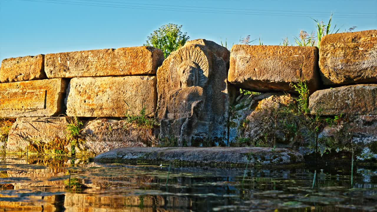 An ancient stone carving at the Holy Water Temple, where the intricate design of a figure is etched into the weathered rock. 8k