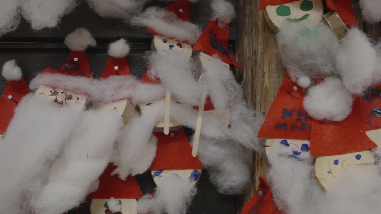Handmade Santa Claus Ornaments Displayed on a Wall