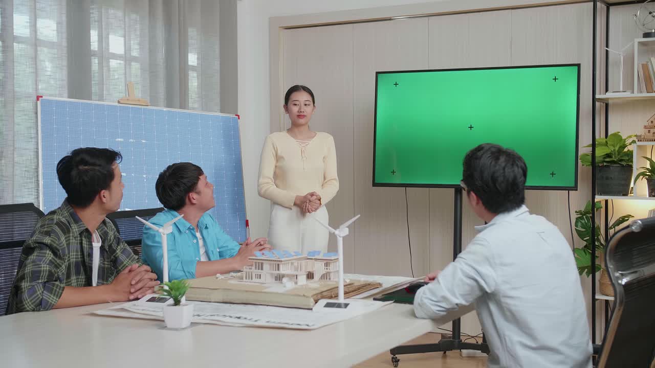 태양전지를 가진 아시아 여성 엔지니어가 사무실에서 녹색 스크린 tv에 대해 성공적으로 프레젠테이션을 하고 관객들이 박수를 치며 인상적 인 느낌을 받았습니다.