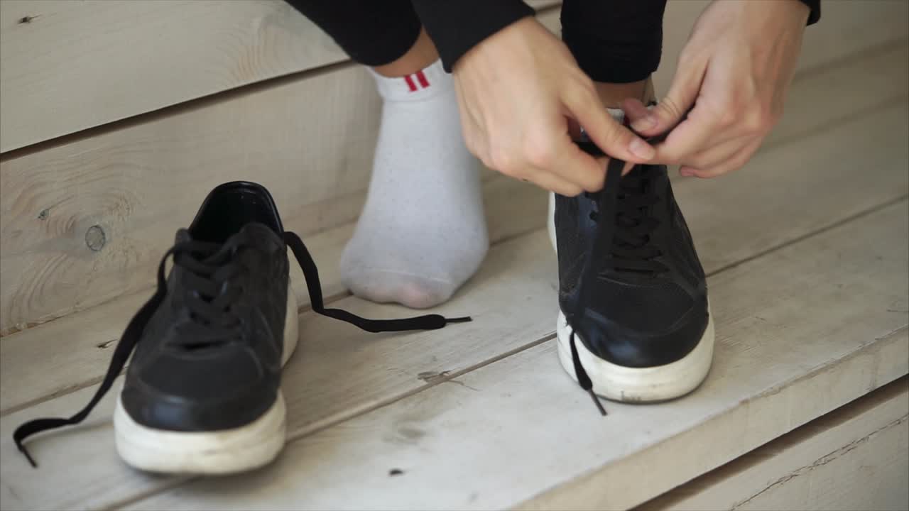Woman Tying Shoelaces on Sneakers