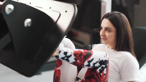 close-up of sporty woman exercising on exercise machine legs in gym
