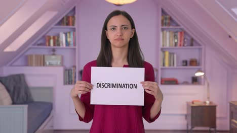 sad indian woman holding discrimination banner