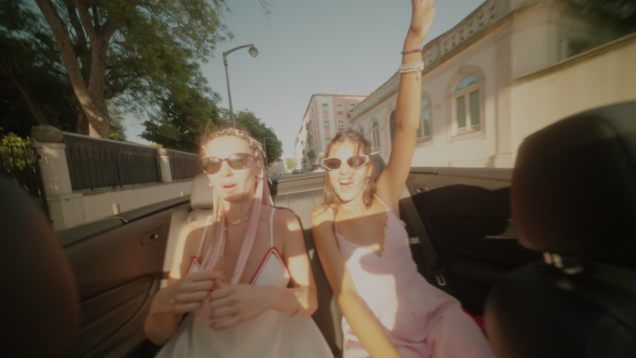 Two women enjoying a convertible ride in the city