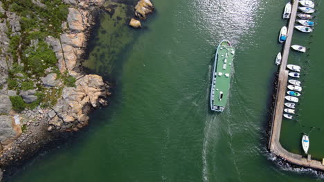 aerial view of a ferry boat cruising over the calm sea in saltholmen, gothenburg, sweden - drone shot