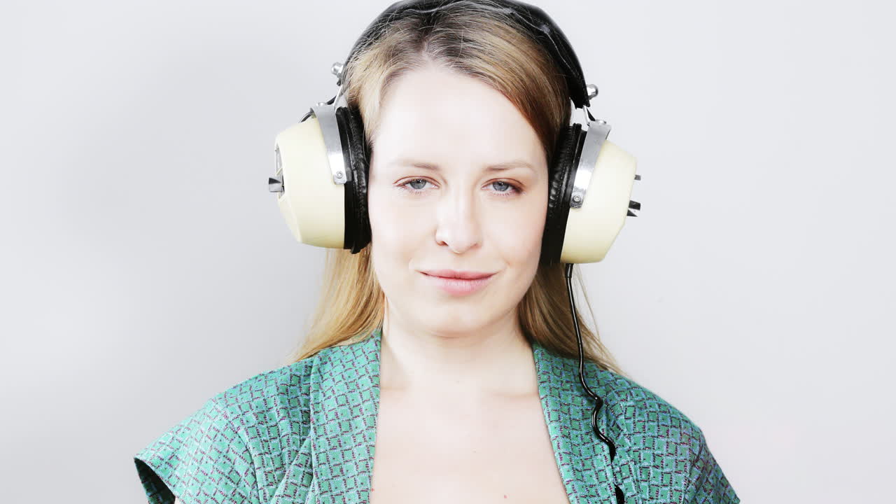 cool female dancer with changing retro headphones to listen to music