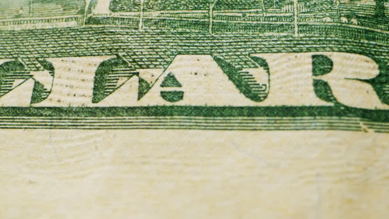 A closeup view of a fifty dollar bill on a polished wooden table, highlighting its intricate design