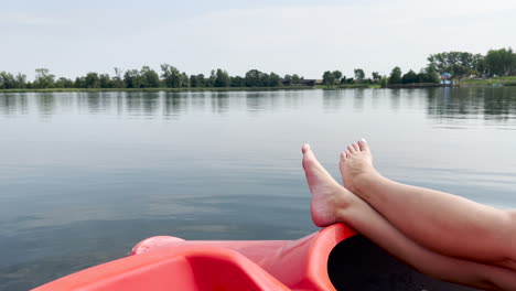 person relaxing on a plastic dinghy boat floating over peaceful lake