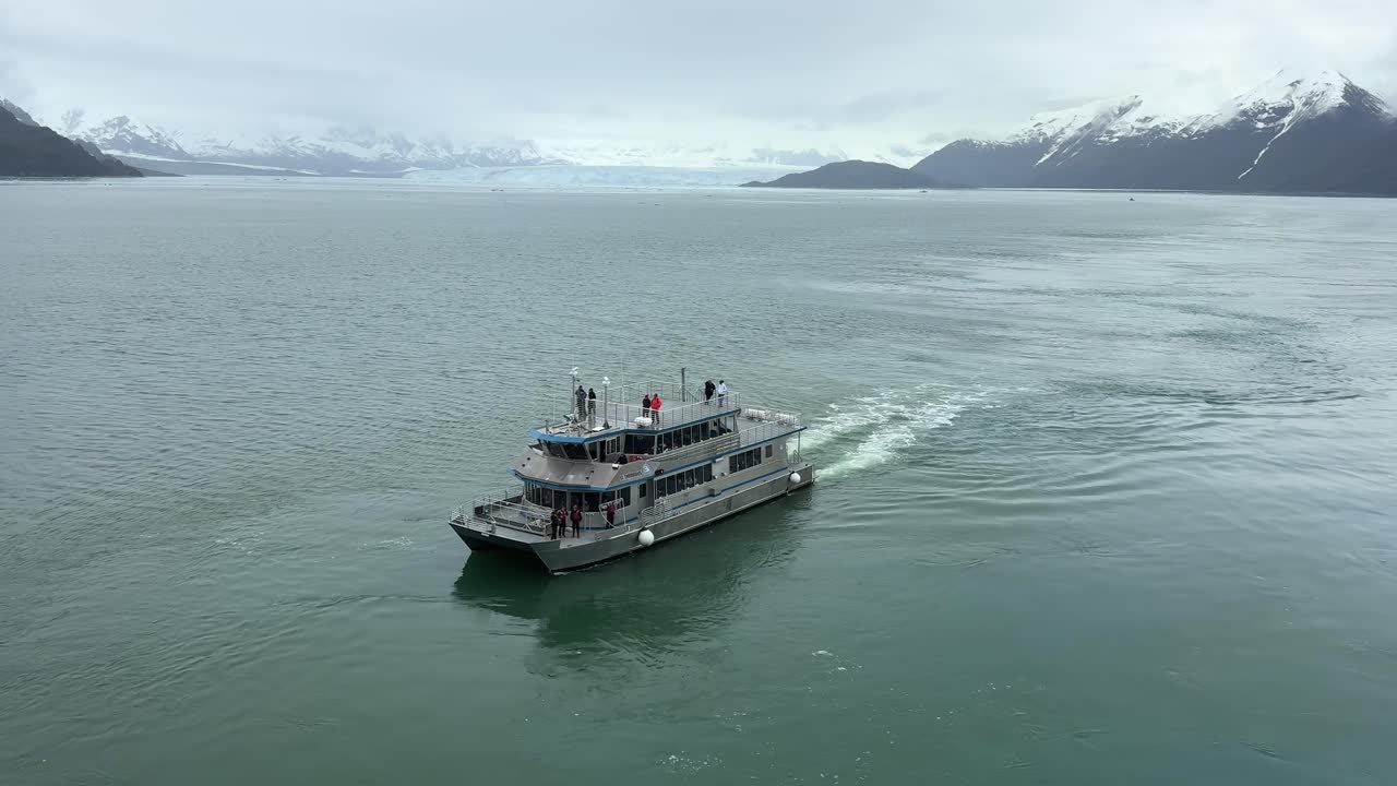 Experience an unforgettable adventure in Glacier Bay, Alaska as a tour boat navigates through pristine waters. Breathtaking views of glaciers and mountains await in this remote paradise.