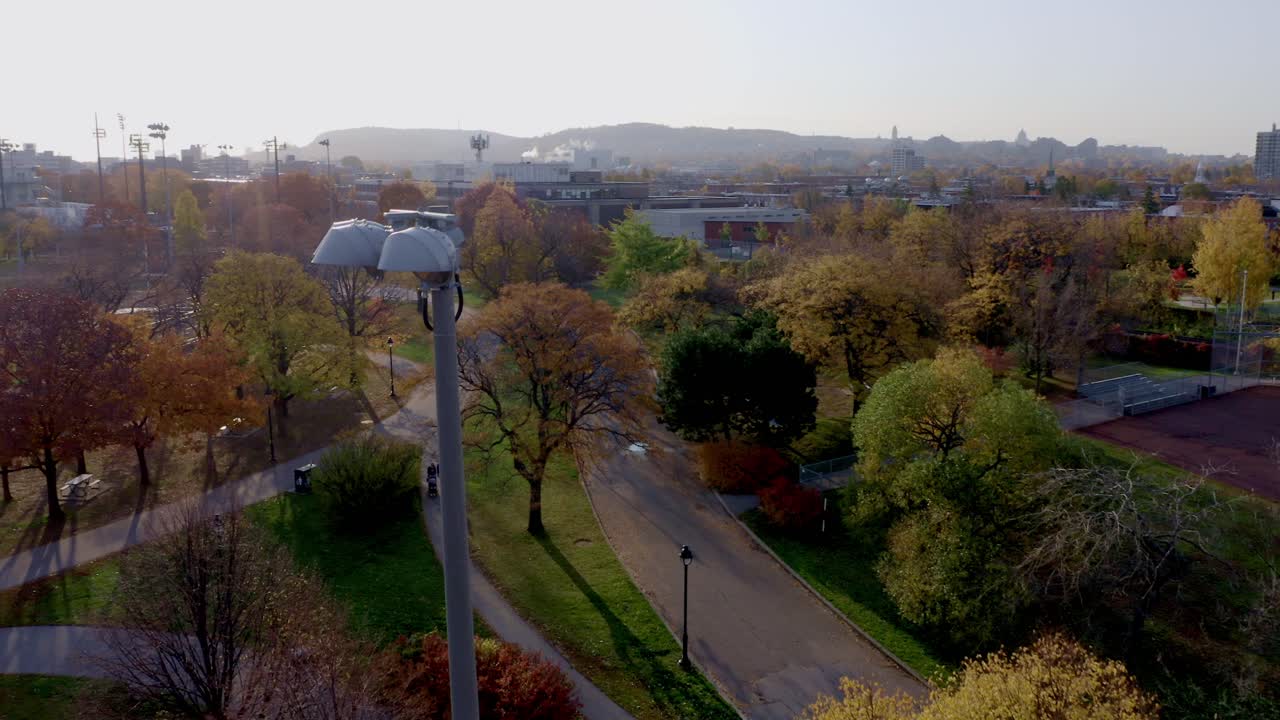 스포츠 경기장과 보행자가 있는 몬트리올의 공공 공원 위를 비행하는 드론
