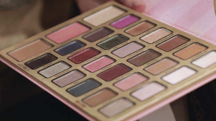 Pennello da trucco e una palette di trucco colorata in uso