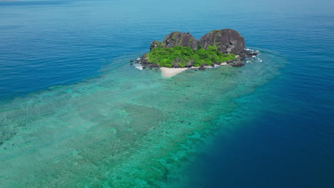 aerial overhead of round reef island with bright lagoon and vibrant reef colors