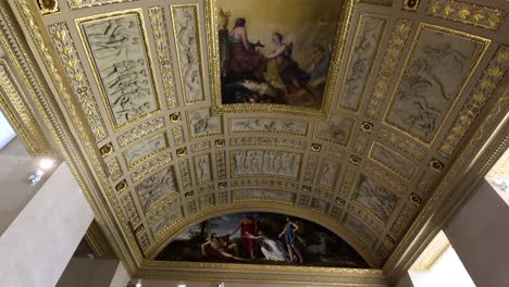 visitors admire the louvre's grand ceiling and artifacts