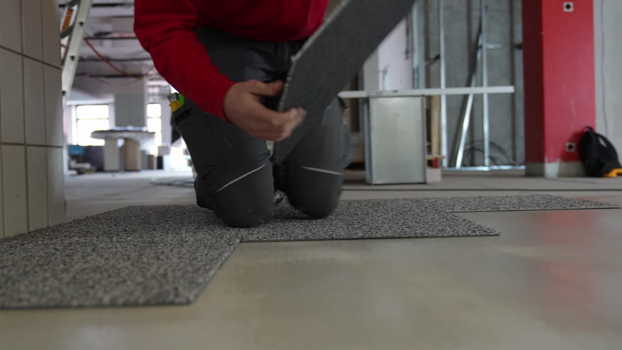 Carpet tiler man laying and installing carpet rug floor wall to wall