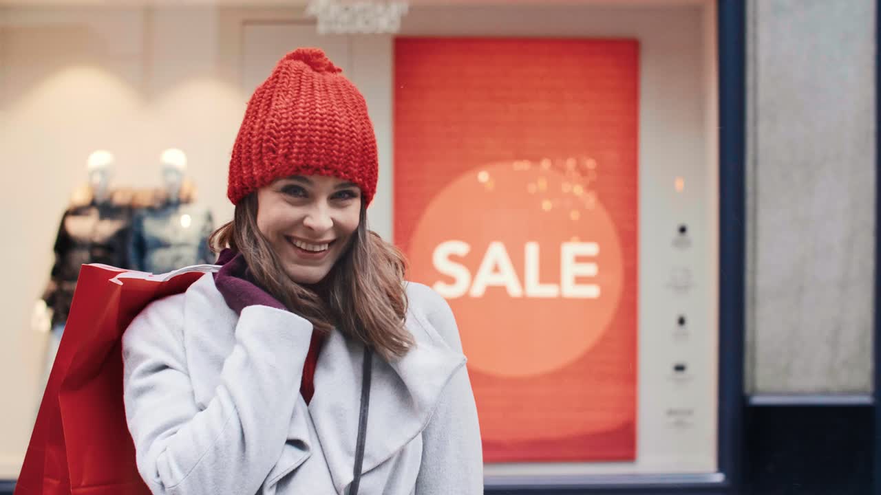 mujer sonriente con bolsas de compras en el centro comercial