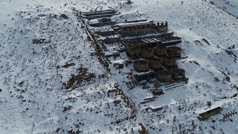 A-drone-orbits-the-rusty-Old-Tintic-Mill-in-Geneloa,-Utah,-revealing-the-decaying-water-tanks,-leaching-tanks,-roasters-and-crusher-built-in-1920