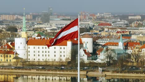latvian flag, riga old town and presidential castle, daugava, spring slow motion
