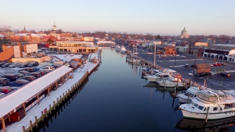 toma aérea mediana del histórico annapolis cubierto de nieve y del callejón ego con el edificio de la capital del estado de maryland al fondo.