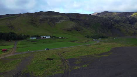 Aerial-Of-Isolated-Vehicle-Traveling-Across-The-Road-Near-Seljavallalaug-Swimming-Pool,-Southern-Iceland