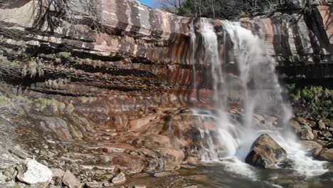 breathtaking waterfall cascading over colorful rock formations, showcasing nature's beauty and serenity in a captivating landscape