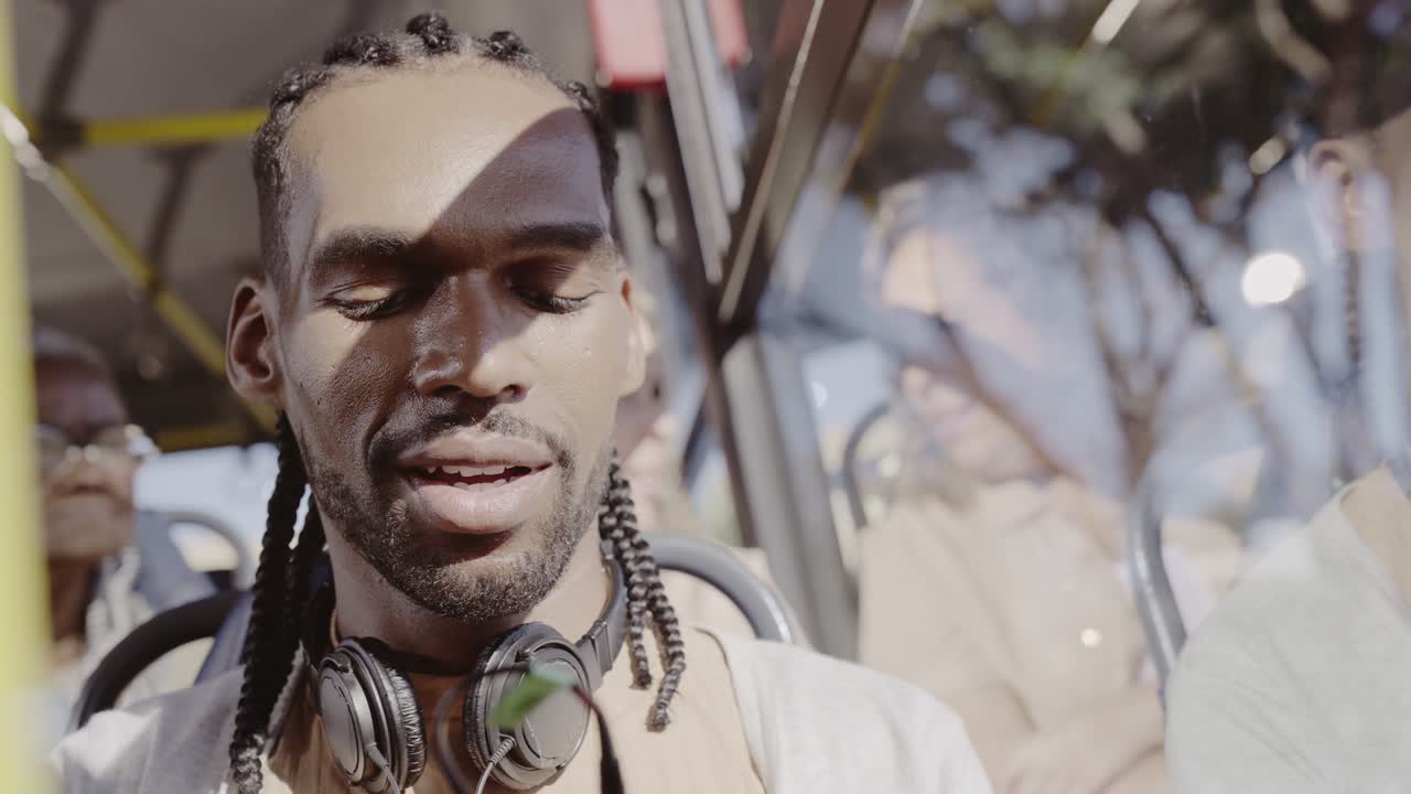 Man with headphones using smartphone on a bus