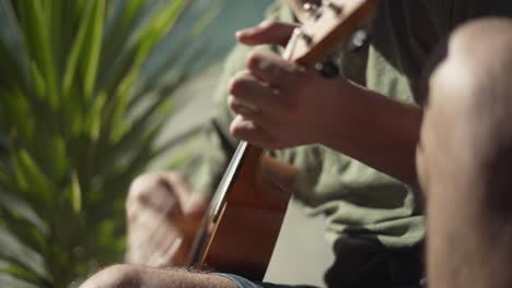 side view of a man playing a ukulele