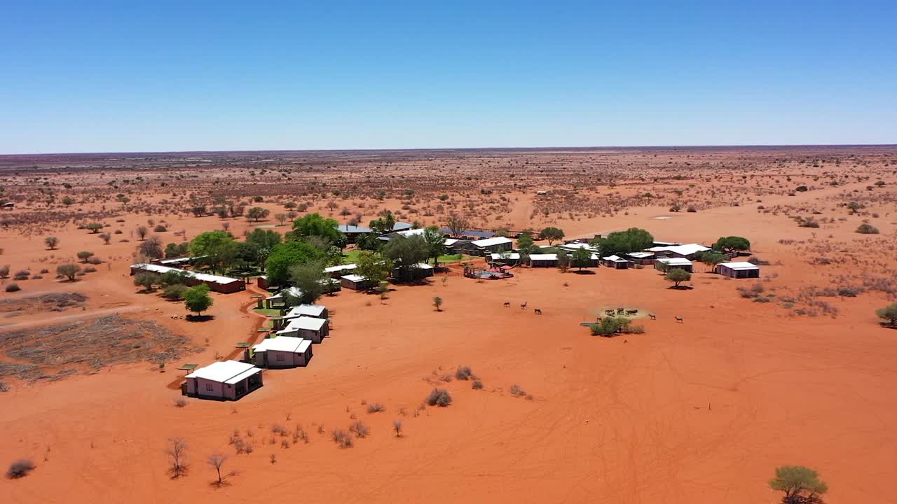 toma de drone de un albergue en namibia con algunos árboles en medio de la nada.
