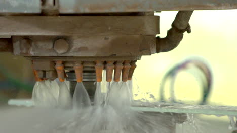 primer plano de una máquina cnc refrigerada por agua que muele los bordes del panel de vidrio