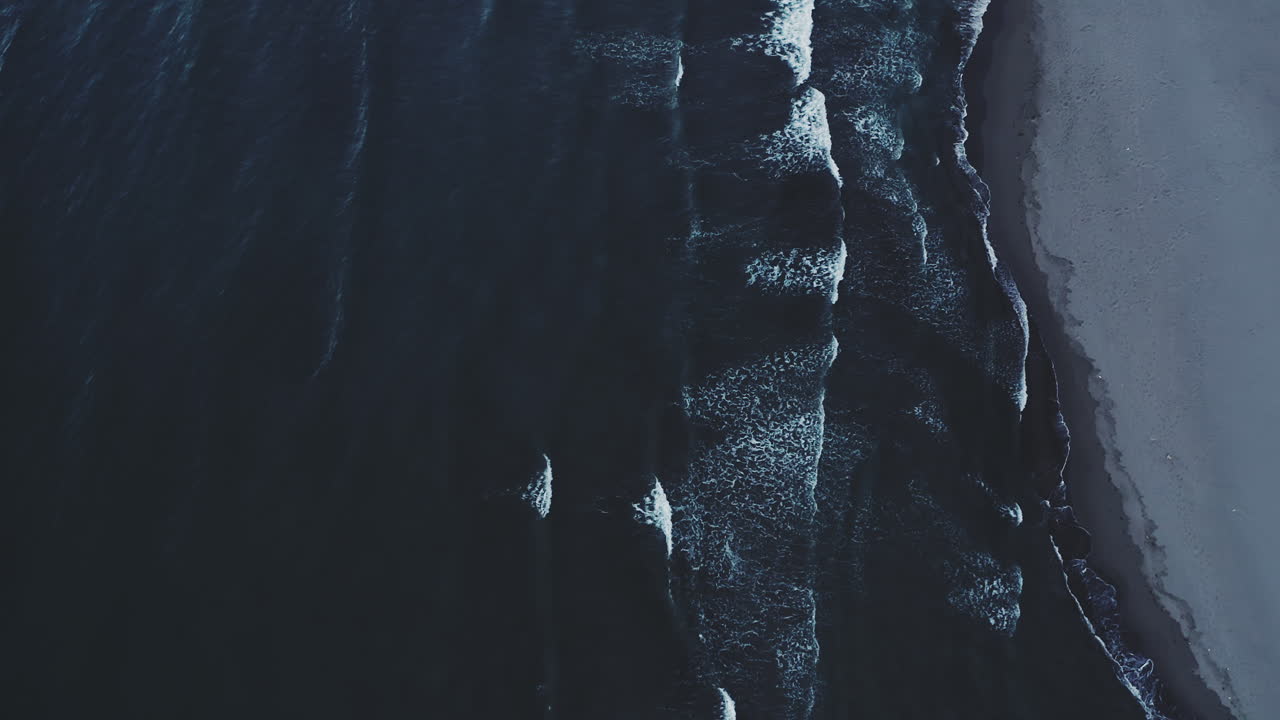 las oscuras olas del océano chocando contra una playa