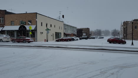 Calle-De-Pueblo-Pequeño-Con-Autos-Y-Nieve-Cayendo-En-El-Día-De-Invierno