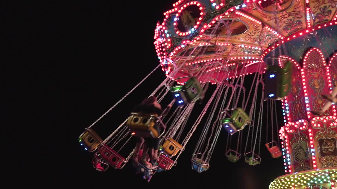 Slow motion colorful carousel at night in a park