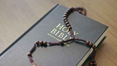 religion, holy bible and rosary on a table