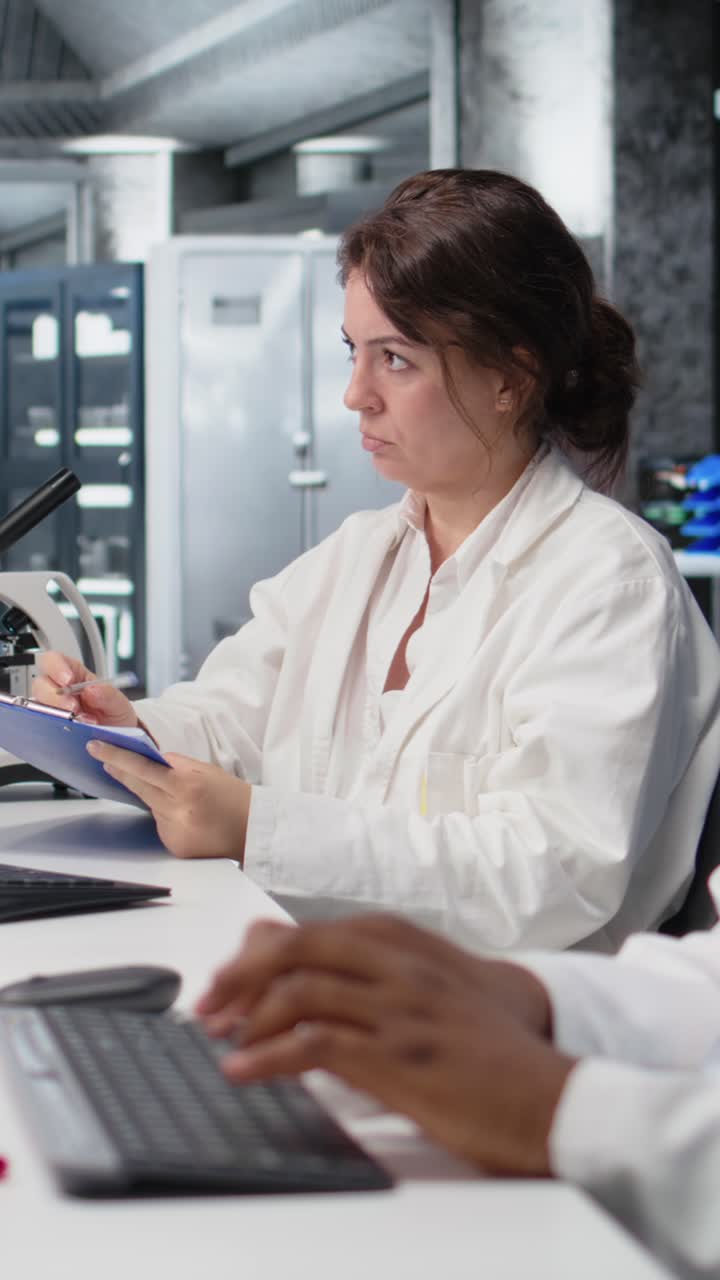 Vertical video Scientist records observations in lab, doing validation of clinical results