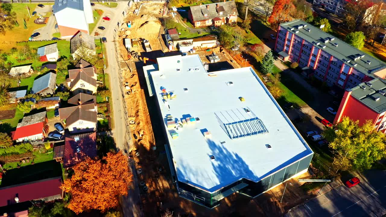 Commercial building development site with residential area and autumn foliage
