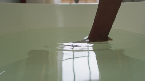 foot of african american attractive woman going into bathtub in bathroom