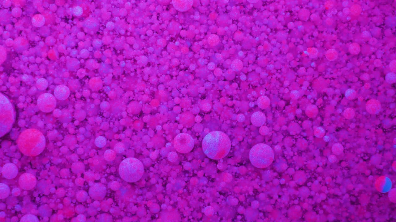 movimiento lento burbujas de color neón brillante aceite pintura fluorescente hermosa color brillante movimiento multicolor de cerca. pintura de neón acrílico. superficie fantástica. abstracto transformación de colores gravitación.