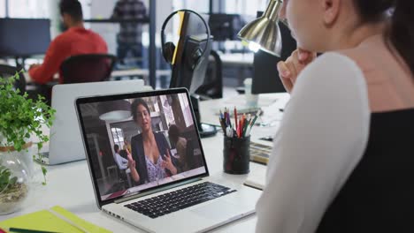 Mujer-Caucásica-Teniendo-Una-Videollamada-Con-Una-Colega-En-Una-Computadora-Portátil-En-La-Oficina