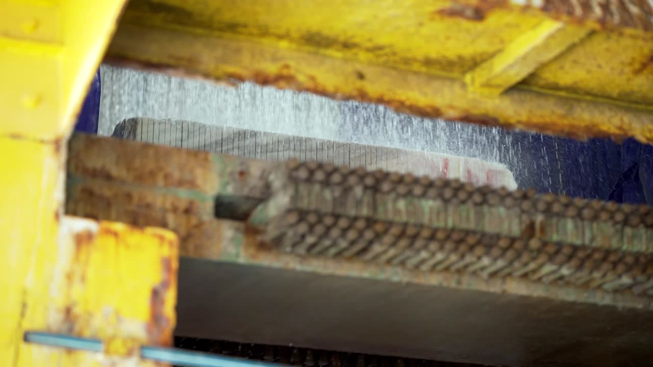 Wide shot of marble block slicing with water-cooled diamond wire saw in industrial marble factory. Wet cutting process, precision machinery, marble slab production, granite and marble processing