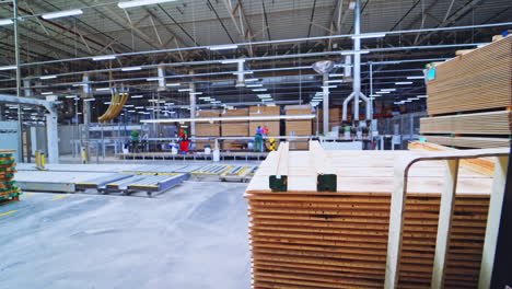 warehouse of wood. piles of boards inside the huge factory for parquet production. electronic cart for carrying wooden material.