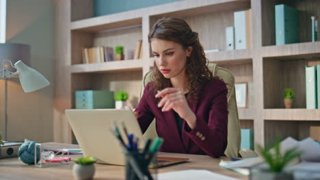 Company leader working computer holding papers. Pensive businesswoman solving