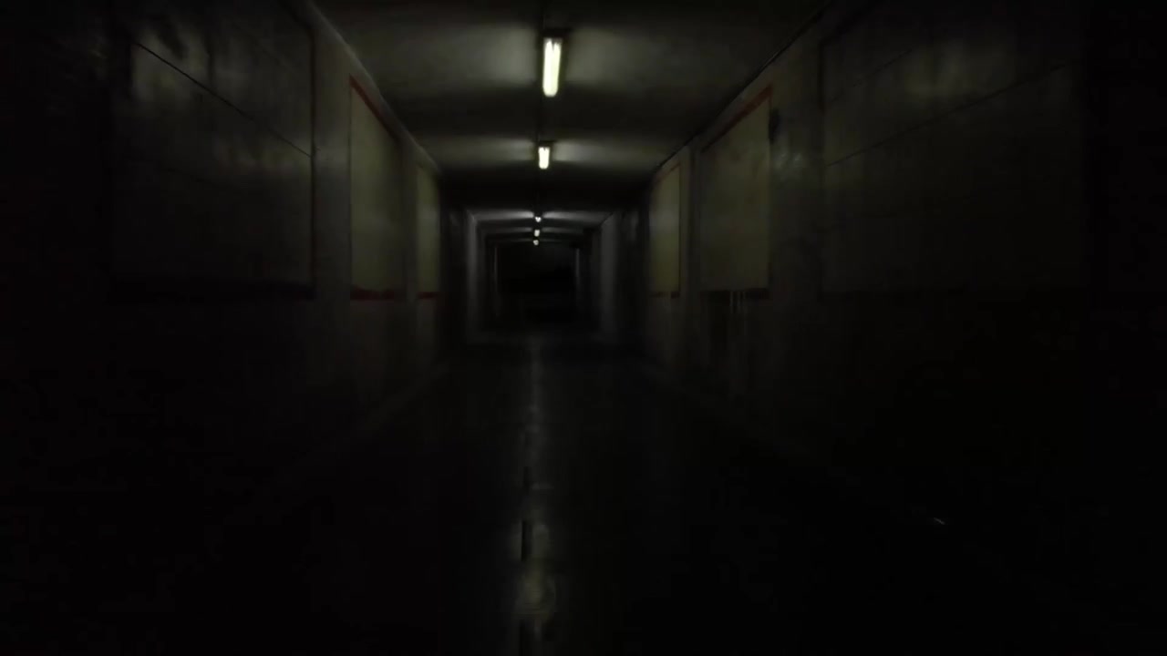 Dolly shot of an underground corridor with creepy flashing lights.