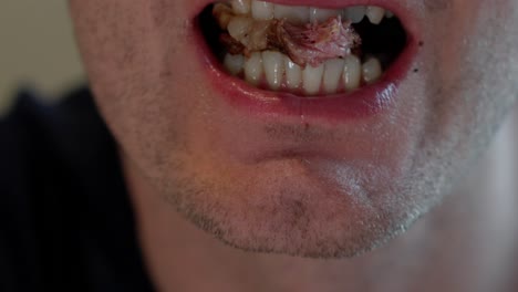 Closeup-of-male-mouth-eating-beef-with-large-fat-chunk,-detailed-slow-motion-showing-chewing-and-fat-entering-mouth