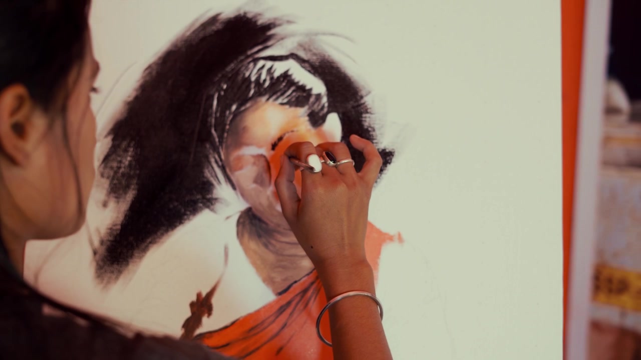 Close up showing talented hand with paintbrush painting beautiful picture