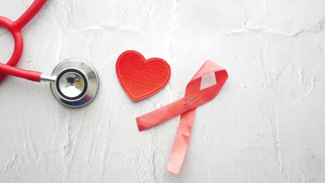 Red-ribbon-hiv,-and-stethoscope-on-pink-background