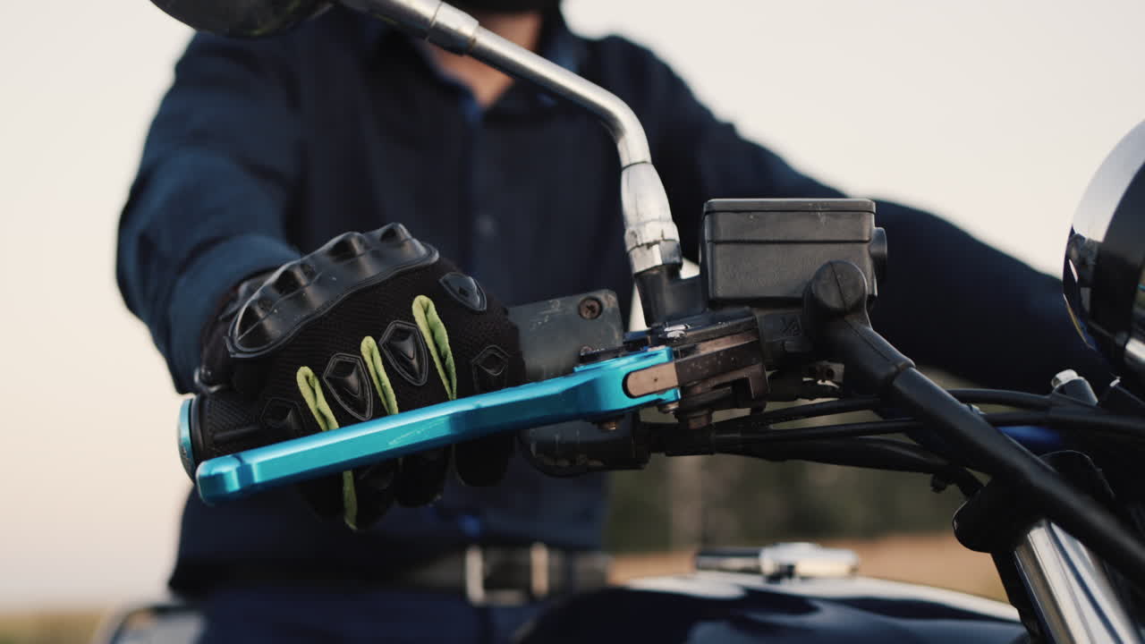 오토바이 운전자의 손이 가속 페달을 돌립니다.