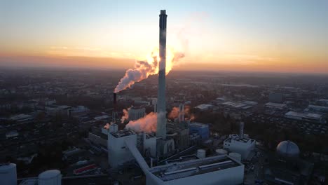 rotating shot of the sunsetting behind the powerplant letting off steam in brunswick