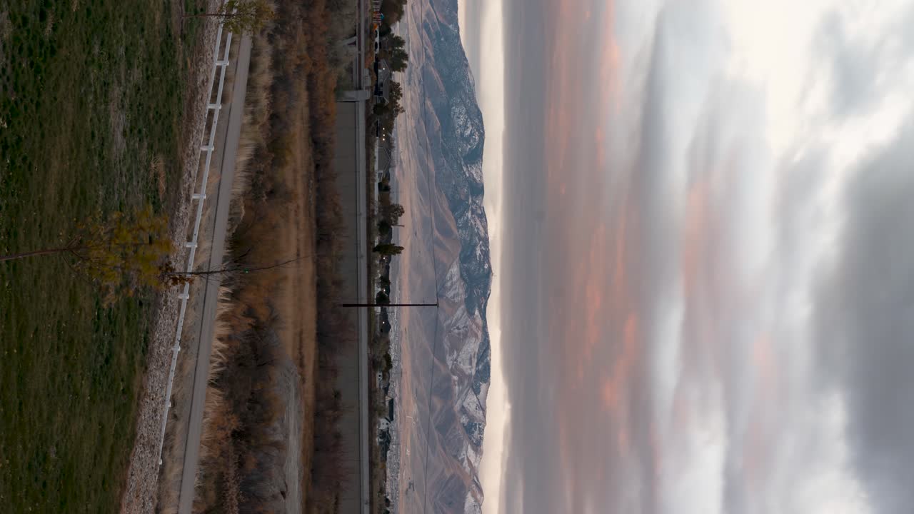Colorful mountain sunrise cloudscape with the light on the mountain peak - vertical orientation time lapse