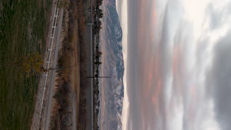 colorful mountain sunrise cloudscape with the light on the mountain peak - vertical orientation time lapse