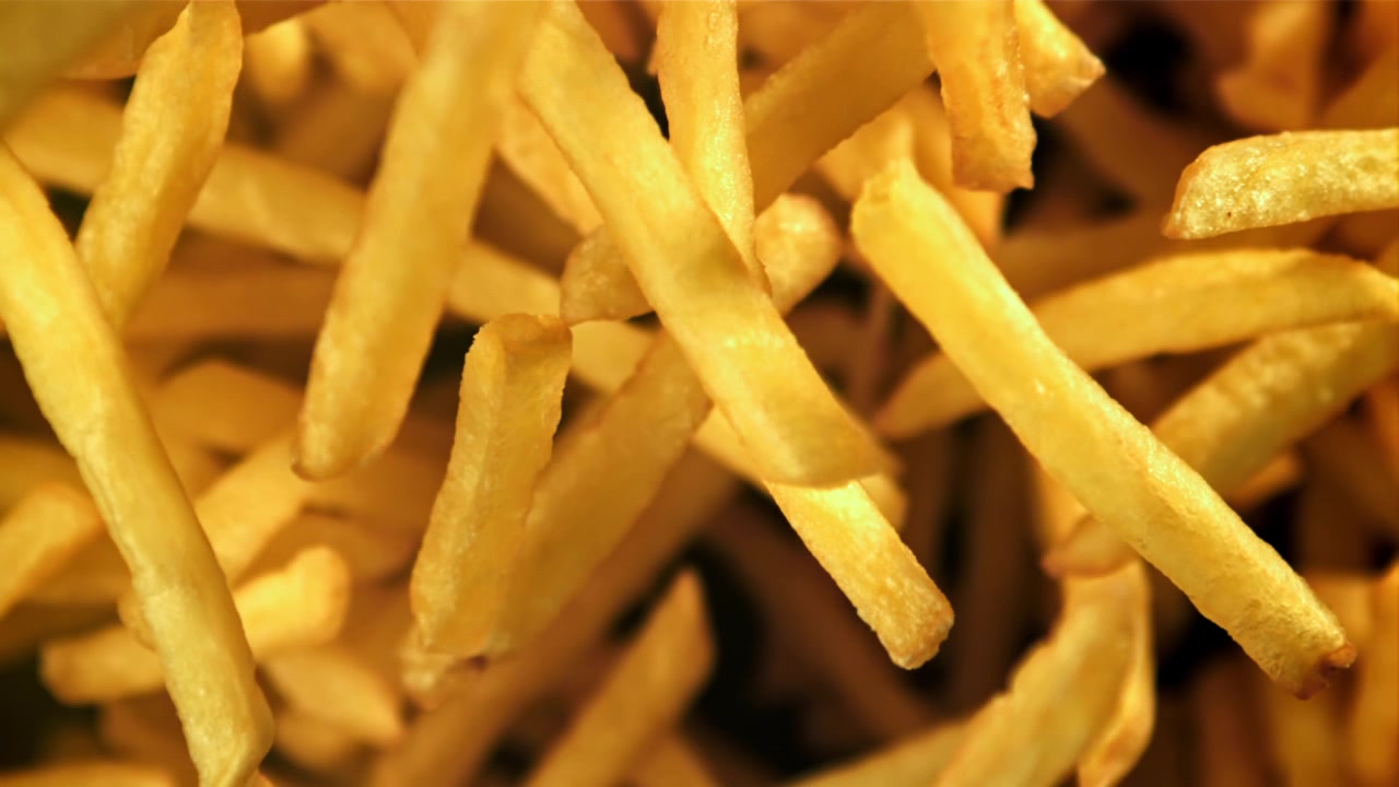 Patatas fritas doradas cayendo en cámara lenta