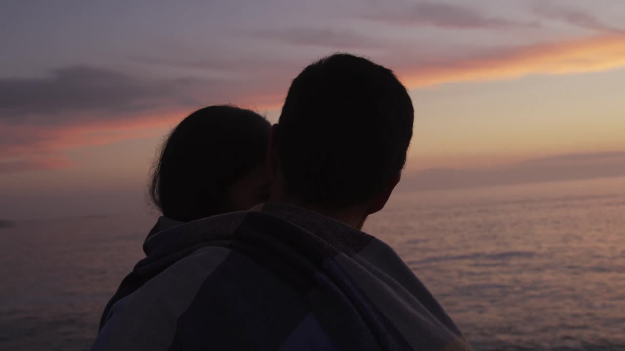 해가 지는 풍경을 즐기는 젊은 부부